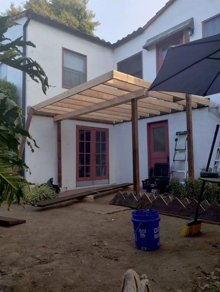 Supportive wood beams laid out on the deck of a Santa Barbara home, under construction